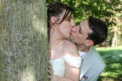 Un couple en tenue de mariage danse sur une place pavée devant un bâtiment historique.