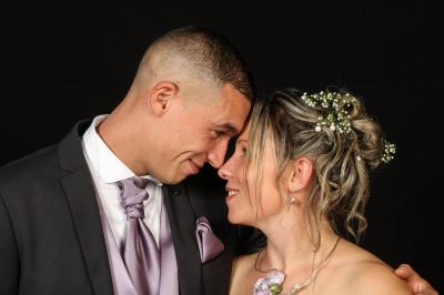Un couple en tenue de mariage danse sur une place pavée devant un bâtiment historique.