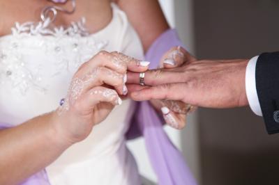 Un couple en tenue de mariage danse sur une place pavée devant un bâtiment historique.