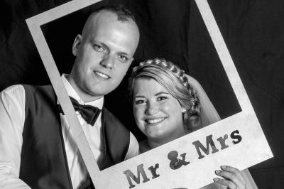 Un couple en tenue de mariage danse sur une place pavée devant un bâtiment historique.