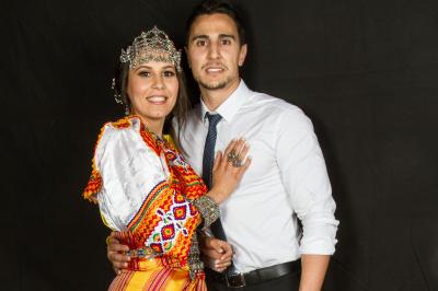 Un couple en tenue de mariage danse sur une place pavée devant un bâtiment historique.