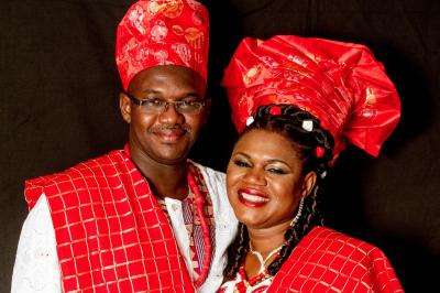 Un couple en tenue de mariage danse sur une place pavée devant un bâtiment historique.