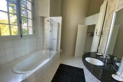 Miniature Location salle Bouesse (Indre) - Chateau de Bouesse en Berry #17 Vase de pivoines roses sur une table en bois, entouré de livres, chandeliers et fauteuils dans un salon élégant.