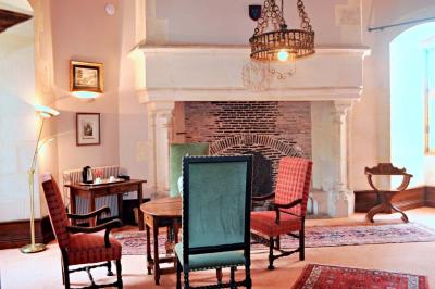 Miniature Location salle Bouesse (Indre) - Chateau de Bouesse en Berry #19 Vase de pivoines roses sur une table en bois, entouré de livres, chandeliers et fauteuils dans un salon élégant.