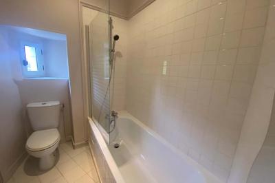 Miniature Location salle Bouesse (Indre) - Chateau de Bouesse en Berry #22 Vase de pivoines roses sur une table en bois, entouré de livres, chandeliers et fauteuils dans un salon élégant.