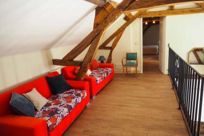 Miniature Location salle Bouesse (Indre) - Chateau de Bouesse en Berry #15 Vase de pivoines roses sur une table en bois, entouré de livres, chandeliers et fauteuils dans un salon élégant.