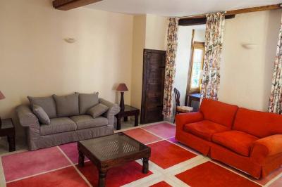 Miniature Location salle Bouesse (Indre) - Chateau de Bouesse en Berry #25 Vase de pivoines roses sur une table en bois, entouré de livres, chandeliers et fauteuils dans un salon élégant.