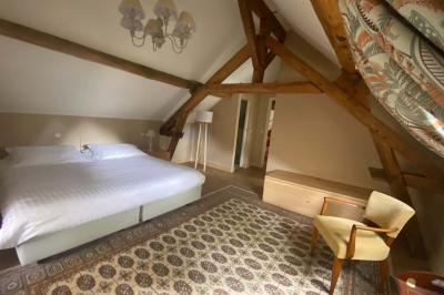 Miniature Location salle Bouesse (Indre) - Chateau de Bouesse en Berry #27 Vase de pivoines roses sur une table en bois, entouré de livres, chandeliers et fauteuils dans un salon élégant.