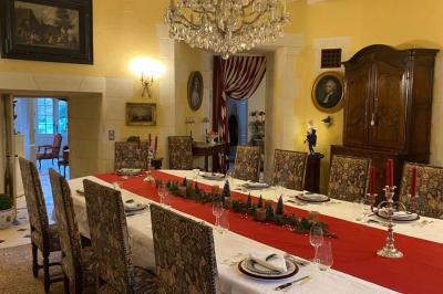 Miniature Location salle Bouesse (Indre) - Chateau de Bouesse en Berry #12 Vase de pivoines roses sur une table en bois, entouré de livres, chandeliers et fauteuils dans un salon élégant.