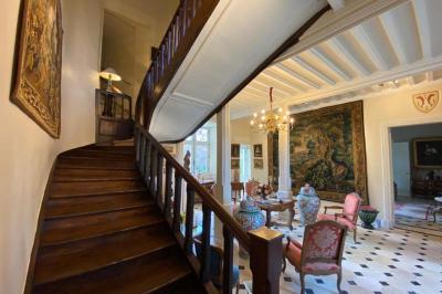 Miniature Location salle Bouesse (Indre) - Chateau de Bouesse en Berry #30 Vase de pivoines roses sur une table en bois, entouré de livres, chandeliers et fauteuils dans un salon élégant.
