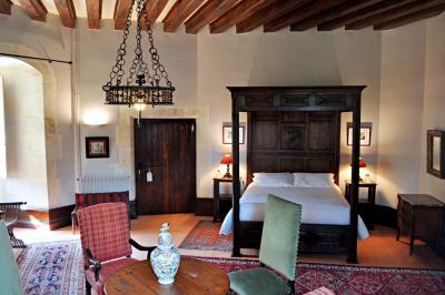 Miniature Location salle Bouesse (Indre) - Chateau de Bouesse en Berry #36 Vase de pivoines roses sur une table en bois, entouré de livres, chandeliers et fauteuils dans un salon élégant.