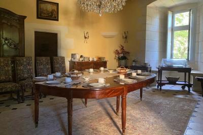 Miniature Location salle Bouesse (Indre) - Chateau de Bouesse en Berry #39 Vase de pivoines roses sur une table en bois, entouré de livres, chandeliers et fauteuils dans un salon élégant.