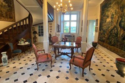 Miniature Location salle Bouesse (Indre) - Chateau de Bouesse en Berry #40 Vase de pivoines roses sur une table en bois, entouré de livres, chandeliers et fauteuils dans un salon élégant.