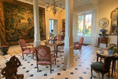 Miniature Location salle Bouesse (Indre) - Chateau de Bouesse en Berry #41 Vase de pivoines roses sur une table en bois, entouré de livres, chandeliers et fauteuils dans un salon élégant.