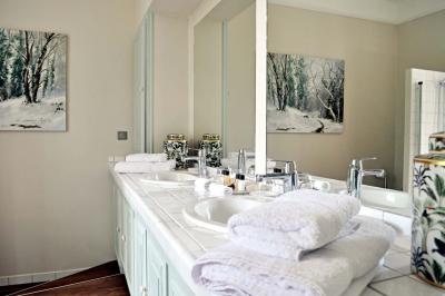 Miniature Location salle Bouesse (Indre) - Chateau de Bouesse en Berry #43 Vase de pivoines roses sur une table en bois, entouré de livres, chandeliers et fauteuils dans un salon élégant.