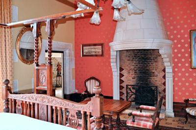 Miniature Location salle Bouesse (Indre) - Chateau de Bouesse en Berry #44 Vase de pivoines roses sur une table en bois, entouré de livres, chandeliers et fauteuils dans un salon élégant.