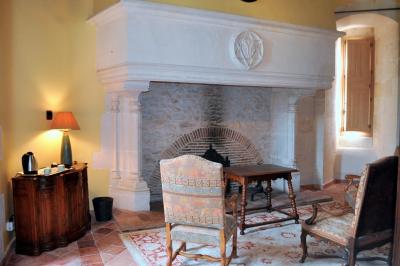 Miniature Location salle Bouesse (Indre) - Chateau de Bouesse en Berry #46 Vase de pivoines roses sur une table en bois, entouré de livres, chandeliers et fauteuils dans un salon élégant.