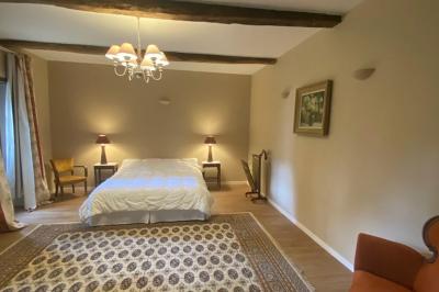 Miniature Location salle Bouesse (Indre) - Chateau de Bouesse en Berry #49 Vase de pivoines roses sur une table en bois, entouré de livres, chandeliers et fauteuils dans un salon élégant.