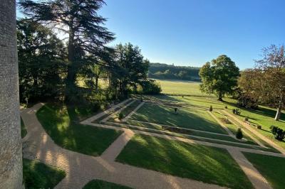 Miniature Location salle Bouesse (Indre) - Chateau de Bouesse en Berry #8 Vase de pivoines roses sur une table en bois, entouré de livres, chandeliers et fauteuils dans un salon élégant.