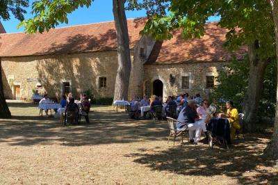 Miniature Location salle Bouesse (Indre) - Chateau de Bouesse en Berry #57 Vase de pivoines roses sur une table en bois, entouré de livres, chandeliers et fauteuils dans un salon élégant.