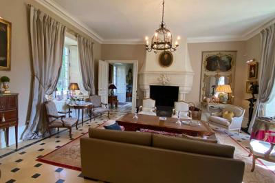 Miniature Location salle Bouesse (Indre) - Chateau de Bouesse en Berry #62 Vase de pivoines roses sur une table en bois, entouré de livres, chandeliers et fauteuils dans un salon élégant.