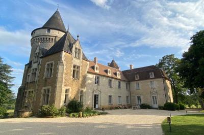 Miniature Location salle Bouesse (Indre) - Chateau de Bouesse en Berry #71 Vase de pivoines roses sur une table en bois, entouré de livres, chandeliers et fauteuils dans un salon élégant.