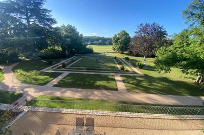 Miniature Location salle Bouesse (Indre) - Chateau de Bouesse en Berry #74 Vase de pivoines roses sur une table en bois, entouré de livres, chandeliers et fauteuils dans un salon élégant.