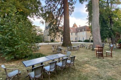 Miniature Location salle Bouesse (Indre) - Chateau de Bouesse en Berry #78 Vase de pivoines roses sur une table en bois, entouré de livres, chandeliers et fauteuils dans un salon élégant.