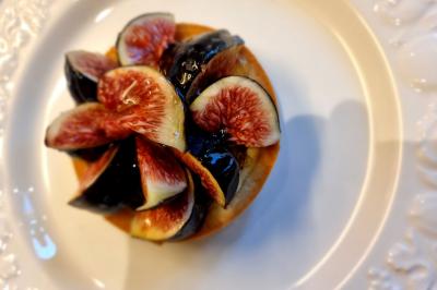 Assiette de légumes variés dressés avec soin, comprenant asperges, carottes, chou-fleur, roquette et sauce décorative.