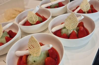 Assiette de légumes variés dressés avec soin, comprenant asperges, carottes, chou-fleur, roquette et sauce décorative.