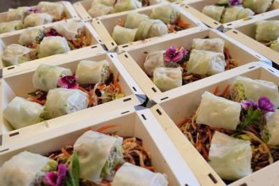 Assiette de légumes variés dressés avec soin, comprenant asperges, carottes, chou-fleur, roquette et sauce décorative.