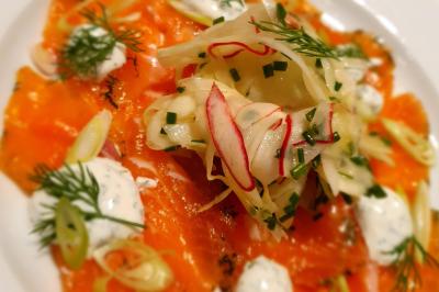 Assiette de légumes variés dressés avec soin, comprenant asperges, carottes, chou-fleur, roquette et sauce décorative.