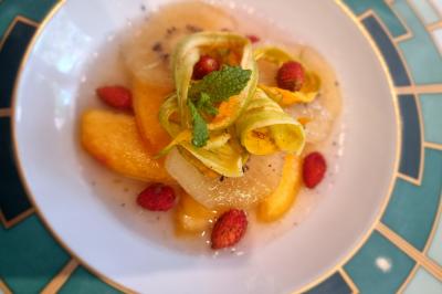 Assiette de légumes variés dressés avec soin, comprenant asperges, carottes, chou-fleur, roquette et sauce décorative.