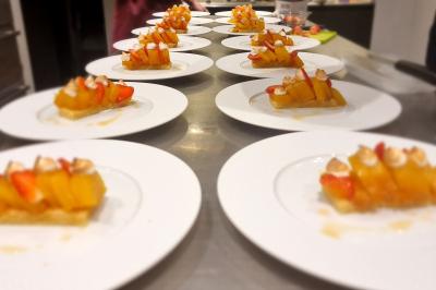 Assiette de légumes variés dressés avec soin, comprenant asperges, carottes, chou-fleur, roquette et sauce décorative.