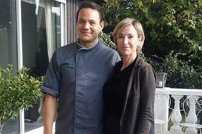 Assiette de légumes variés dressés avec soin, comprenant asperges, carottes, chou-fleur, roquette et sauce décorative.