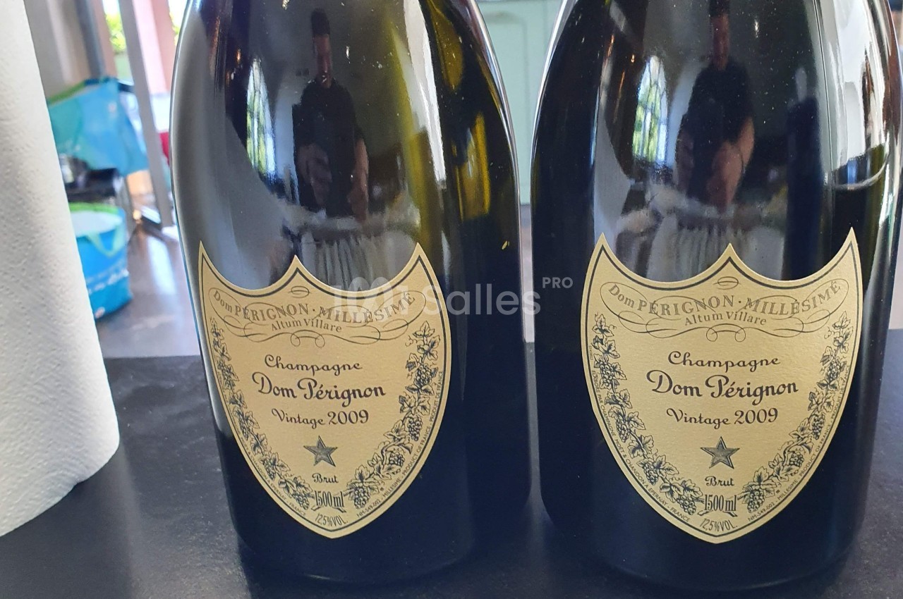 Deux bouteilles de champagne Dom Pérignon millésime 2009 posées sur une surface noire.
