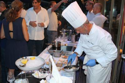 Miniature Location salle Lille (Nord) - La Criée Lomme #9 Des personnes se servent à un buffet en plein air, avec un chef en tenue blanche préparant des plats.