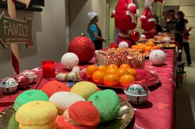 Deux personnes assises dans un buggy bleu en extérieur, discutant et manipulant des objets, avec un homme debout à côté.