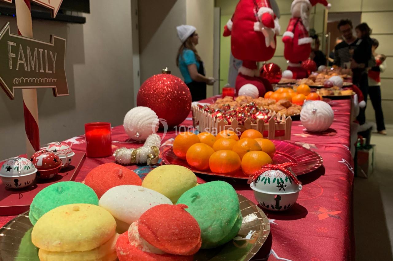 Table décorée sur le thème de Noël avec des pâtisseries colorées, des fruits et des décorations festives.