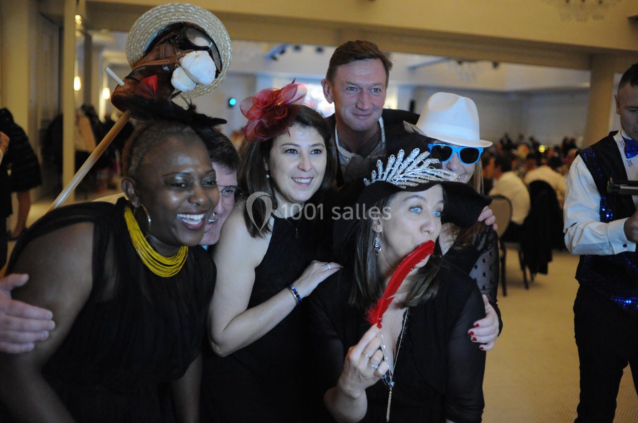 Un groupe de personnes déguisées posant joyeusement lors d'un événement festif en intérieur.