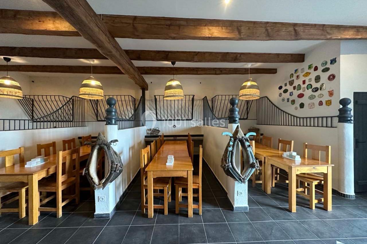 Salle de restaurant avec tables et chaises en bois, décor maritime comprenant des bouées et des éléments muraux colorés.