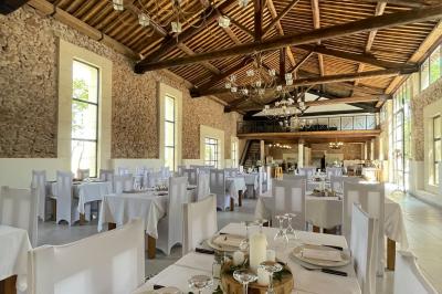 Paysage rural avec un chemin en gravier, des plantes, des champs verdoyants et un ciel partiellement nuageux.