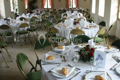 Miniature Location salle Saint-Aubin-sur-Gaillon (Eure) - Château de Beauchêne #4 Cheminée en pierre avec poutres en bois apparentes, ornée d'une composition florale dans une pièce lumineuse.