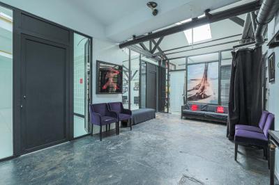 Miniature Location salle Paris 18 (Paris) - Loft Montmartre #5 Balcon étroit avec sol en bois, mur en pierre, grillage métallique et vue sur un jardin arboré.