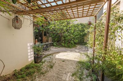 Miniature Location salle Paris 18 (Paris) - Loft Montmartre #12 Balcon étroit avec sol en bois, mur en pierre, grillage métallique et vue sur un jardin arboré.