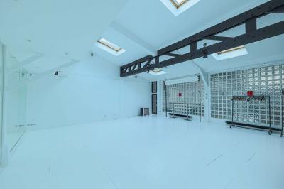 Miniature Location salle Paris 18 (Paris) - Loft Montmartre #11 Balcon étroit avec sol en bois, mur en pierre, grillage métallique et vue sur un jardin arboré.