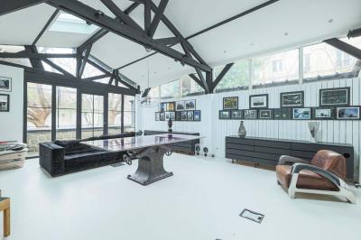 Miniature Location salle Paris 18 (Paris) - Loft Montmartre #6 Balcon étroit avec sol en bois, mur en pierre, grillage métallique et vue sur un jardin arboré.