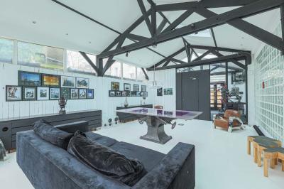 Miniature Location salle Paris 18 (Paris) - Loft Montmartre #7 Balcon étroit avec sol en bois, mur en pierre, grillage métallique et vue sur un jardin arboré.