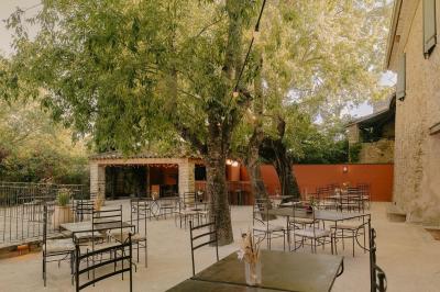 Vue aérienne d'une grande maison en pierre avec piscine, entourée de forêts et de champs sous un ciel dégagé.