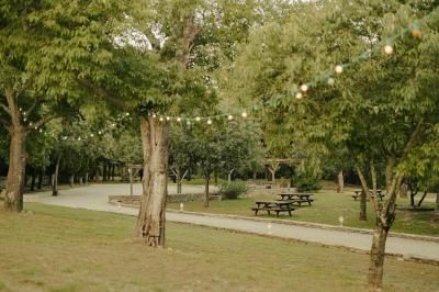 Vue aérienne d'une grande maison en pierre avec piscine, entourée de forêts et de champs sous un ciel dégagé.